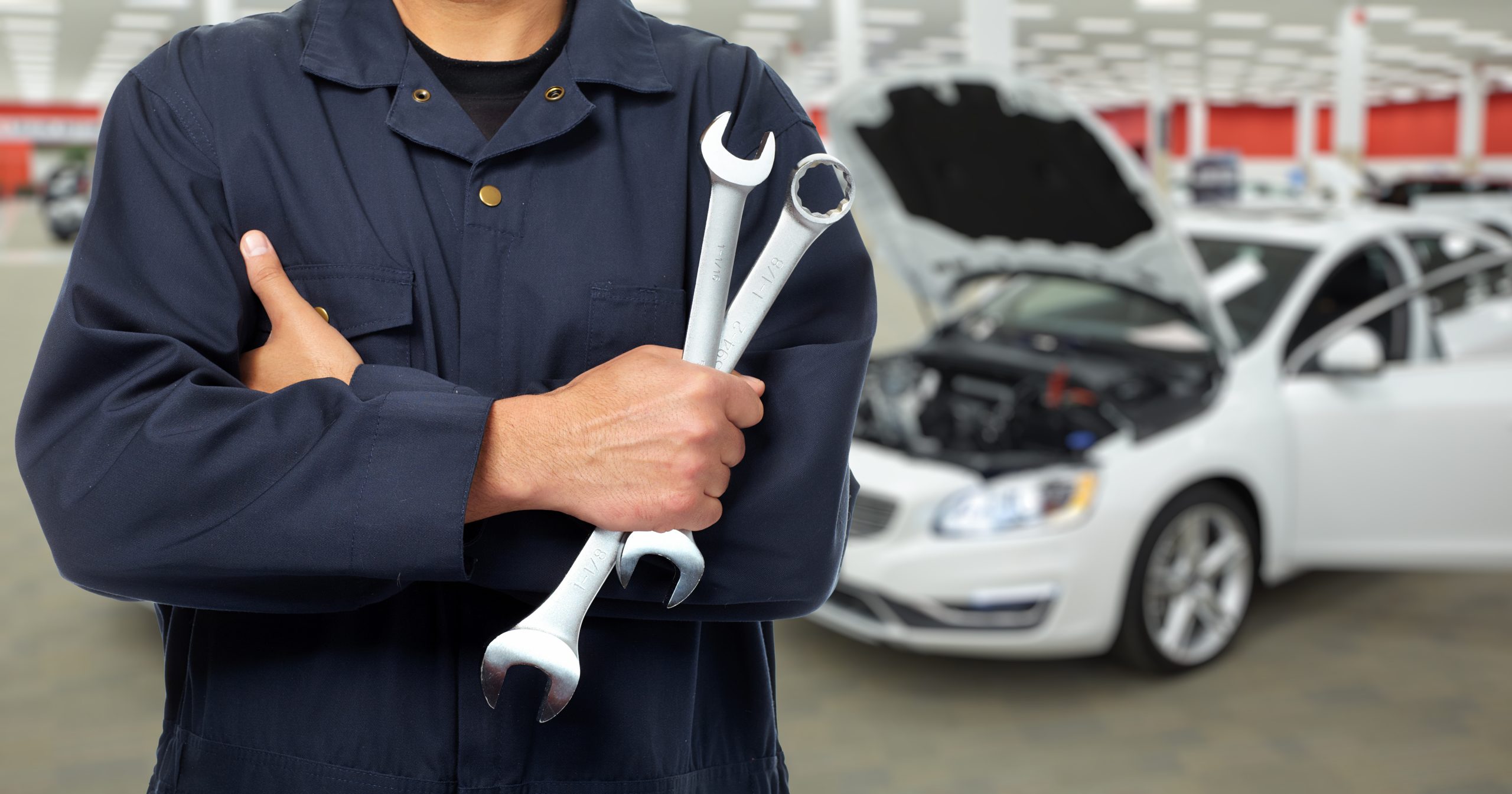 a mechanic's hands with tools in them at an auto repair service shop